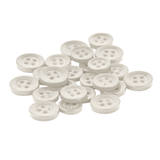 A set of small, round, white Replacement Shirt Buttons from a tailor’s kit scattered on a white background.