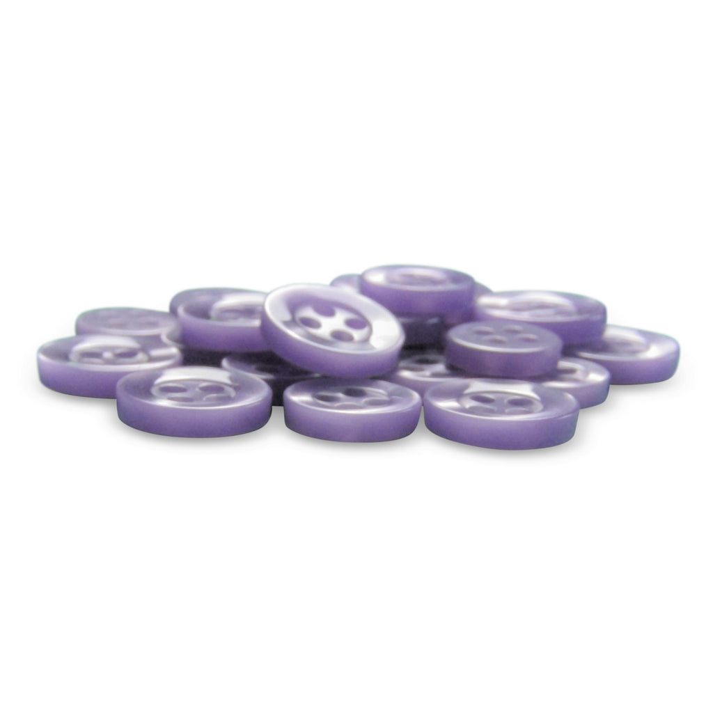A pile of flat, round Replacement Shirt Buttons with a matte finish and four holes each lies on a white surface.