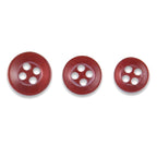 Three Replacement Shirt Buttons in red poly-nylon, each a different size with four holes and a matte finish, are arranged in a row on a white background—ideal additions to any tailor’s button kit.