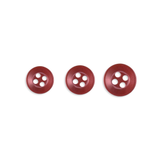 Three Replacement Shirt Buttons—red, four-hole, poly-nylon with a matte finish in assorted sizes—are arranged in a row on a white background, ideal for any tailor’s kit.
