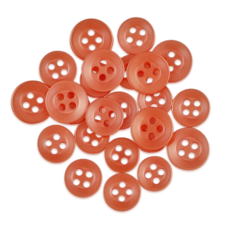 A collection of round, orange Replacement Shirt Buttons from a tailor's kit scattered on a white background.